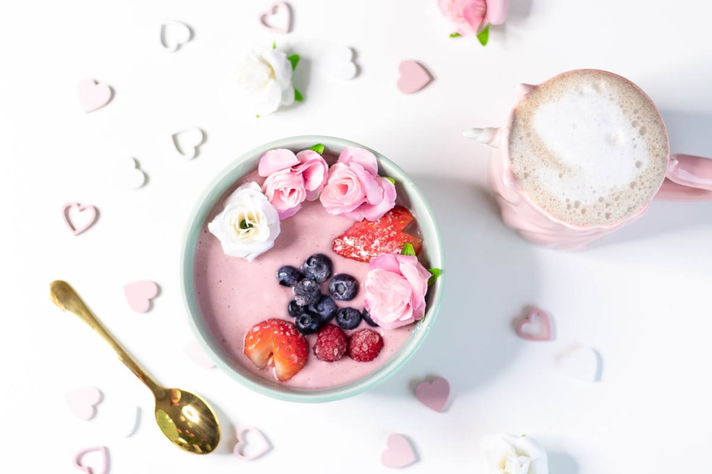 pink Valentine's Day breakfast with smoothie bowl and cup of coffee